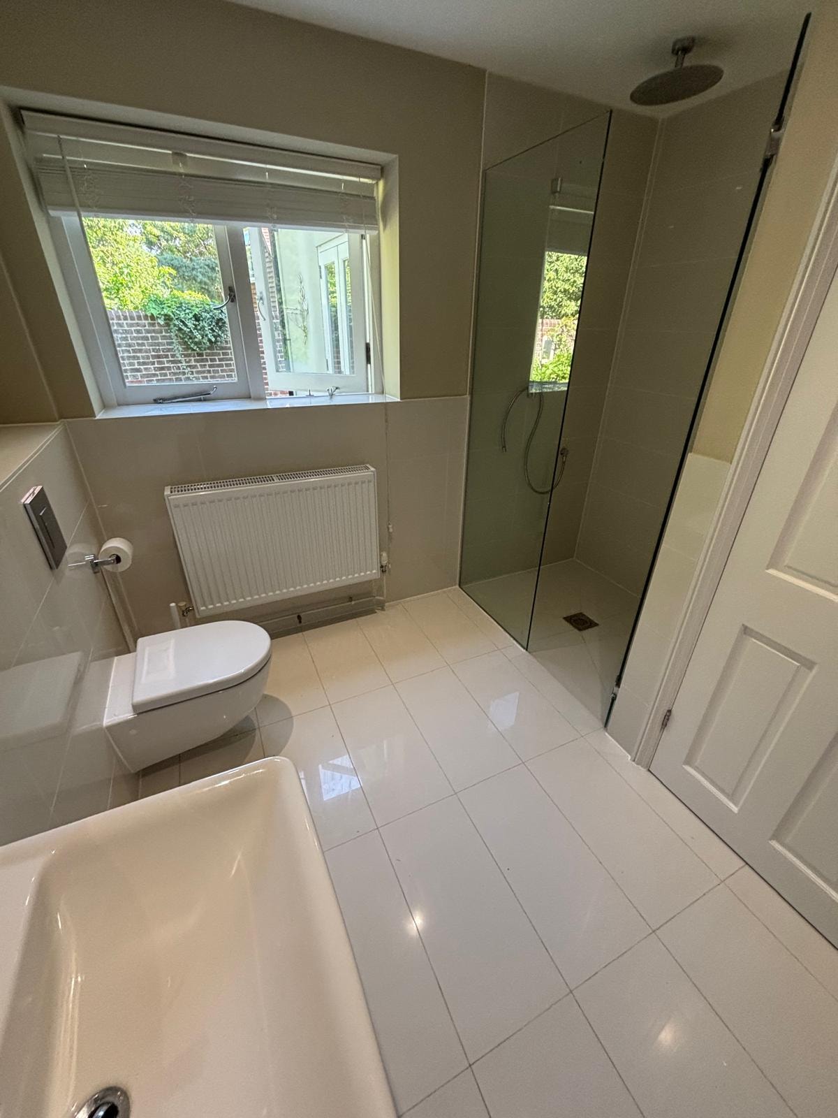 Bathroom reseal — modern ensuite with tiled flooring, walk-in shower and bath