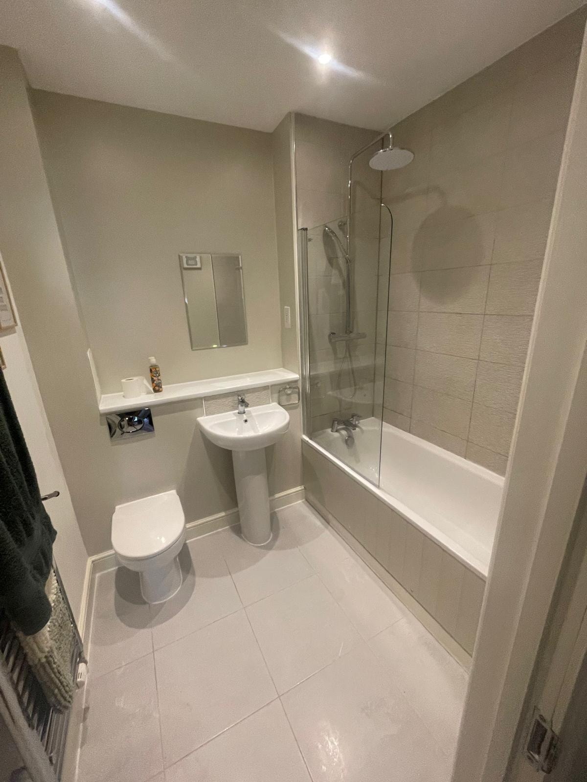 Bathroom reseal — modern ensuite with white fixtures and tiled shower enclosure