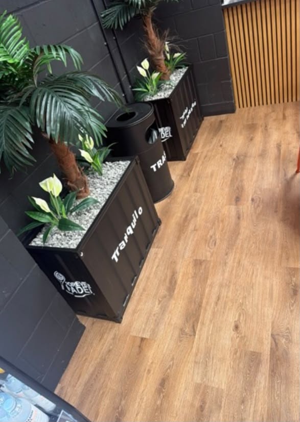 Forever Padel — branded planters and tropical plants in reception area