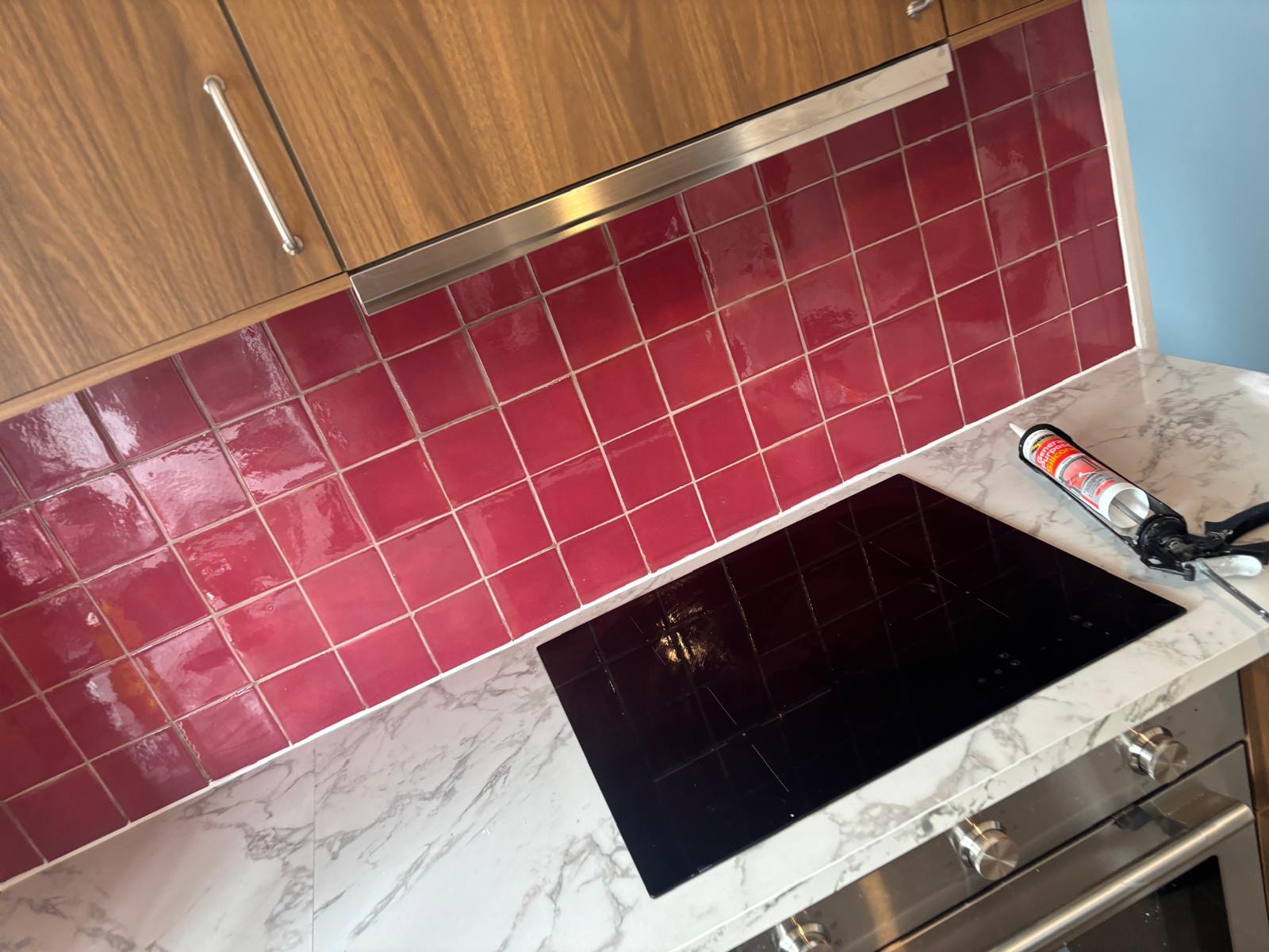 Red kitchen splashback with marble worktop — mastic sealed