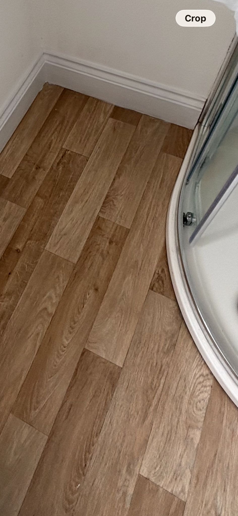 LVT floor sealing — wood-effect planks sealed to shower enclosure