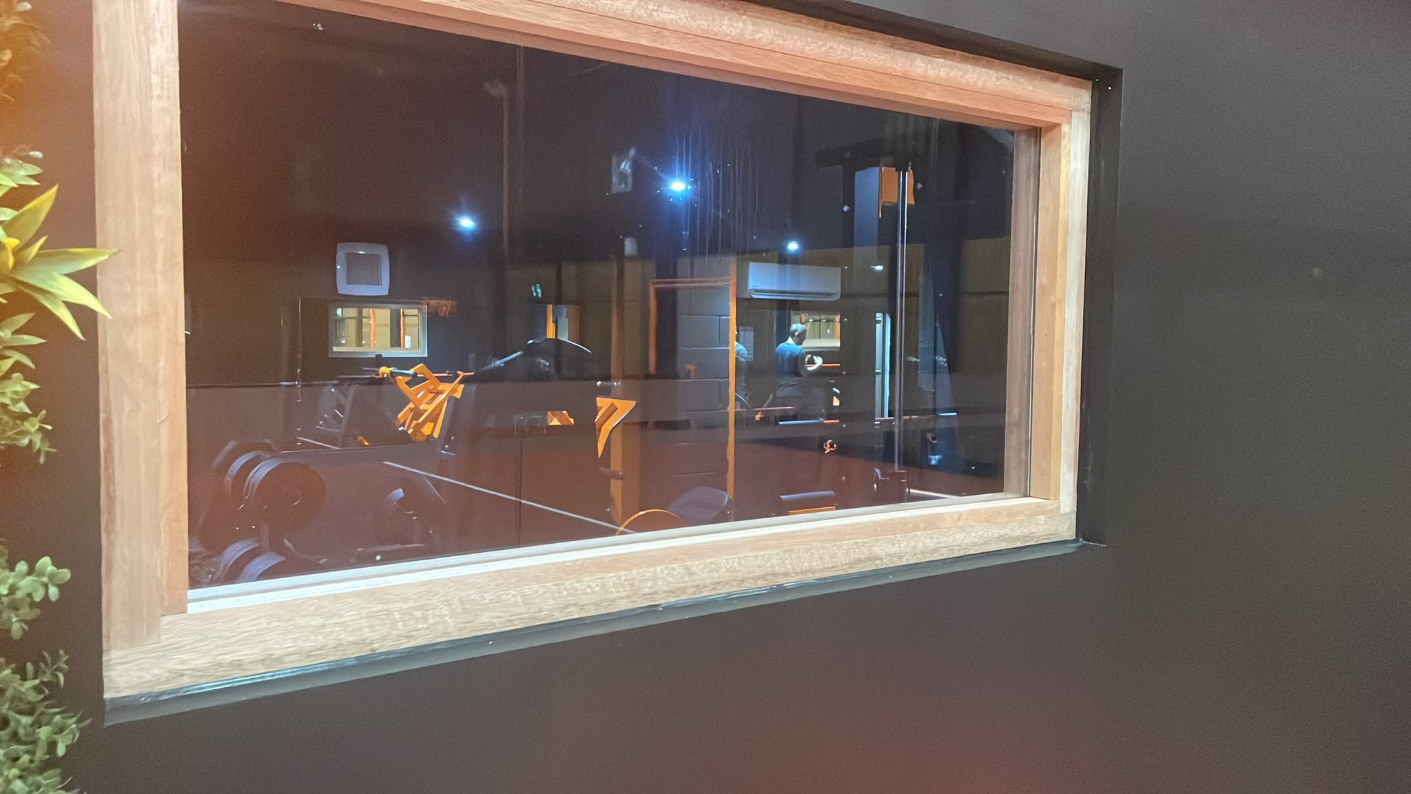 Commercial window sealed with silicone — oak frame and dark surround
